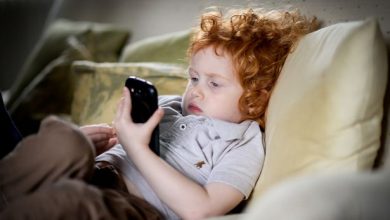 Young child using phone - مدونة التقنية العربية